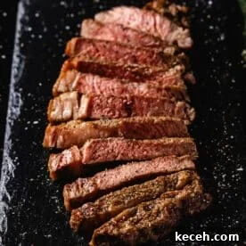 Crispy Air Fryer Steak with Roasted Potatoes & Green Beans 11 Sliced ribeye on black serving platter.