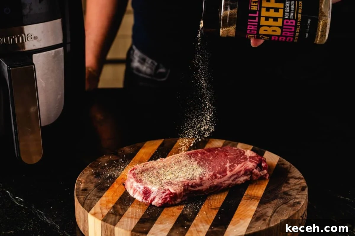 Crispy Air Fryer Steak with Roasted Potatoes & Green Beans 3 Ribeye on cutting board being sprinkled with Beef Rub.