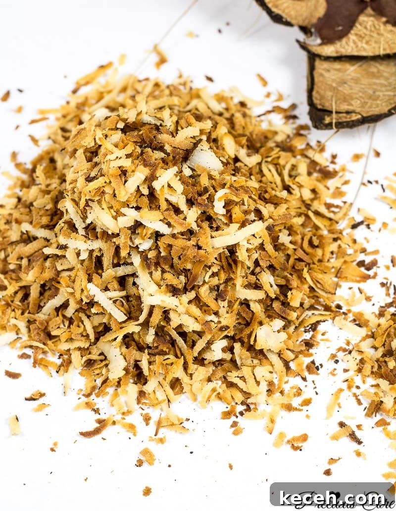 Toasted Coconut Flakes: Sweet Coconut Snack Recipe 3 Toasted coconut flakes on a white surface.