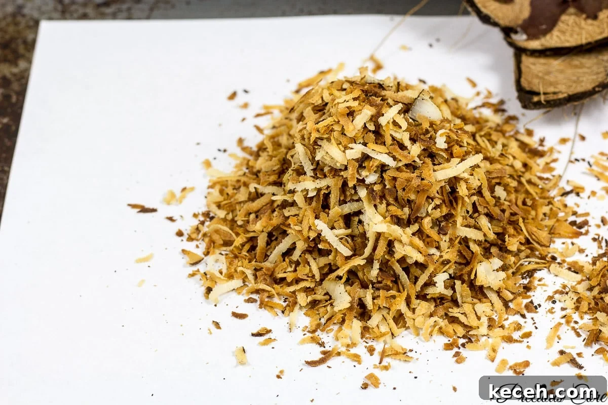 Toasted Coconut Flakes: Sweet Coconut Snack Recipe 4 Toasted coconut flakes on paper.