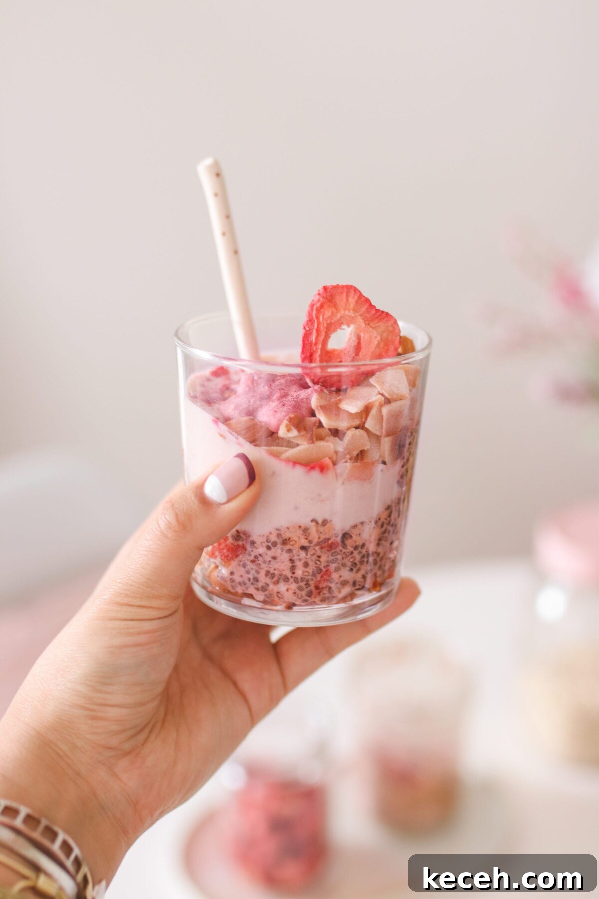Strawberry Shortcake Overnight Oats Recipe – Make Ahead Breakfast 2 a hand holding a jar of overnight oats with strawberries