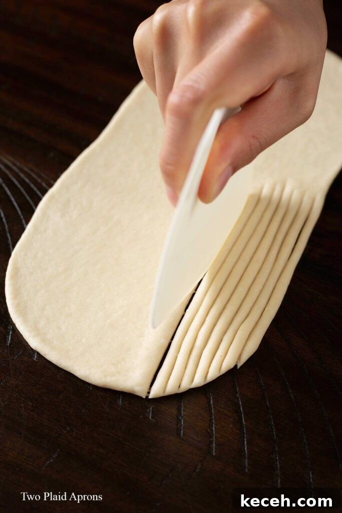 Cutting the dough with a bowl scraper.