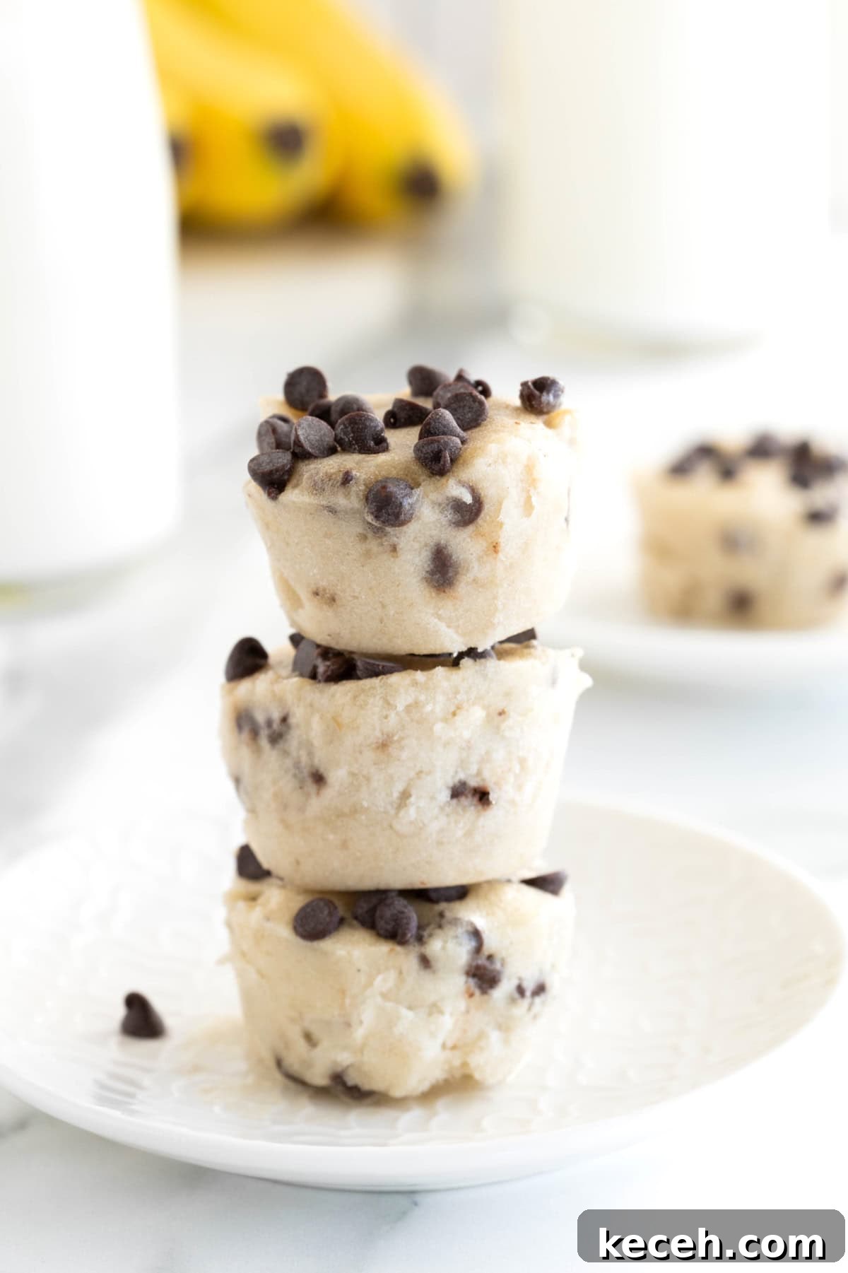 Banana Chocolate Chip Ice Cream Bites — 2-Ingredient Frozen Treats 6 Three banana chocolate chip frozen bites stacked on a white plate.