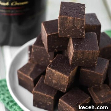 Decadent Baileys Chocolate Fudge Recipe 13 Baileys fudge stacked on white plate.