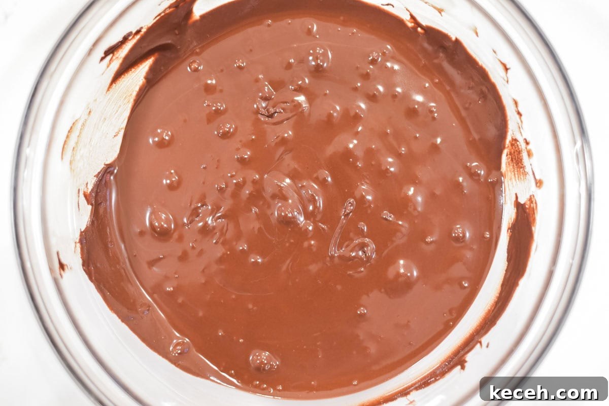 Decadent Baileys Chocolate Fudge Recipe 4 Melted chocolate and condensed milk in glass bowl.