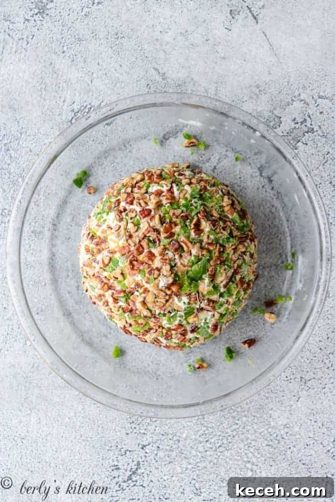 Spicy Jalapeño Cheese Ball Recipe for Parties 5 The ball has been coated in more peppers and pecans.