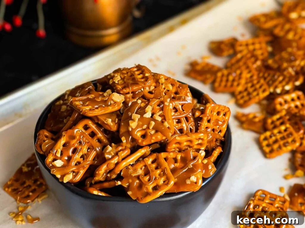 Buttery Toffee Pretzel Snacks: Sweet & Crunchy Recipe 2 Butter toffee pretzels in a dark bowl on the baking sheet.