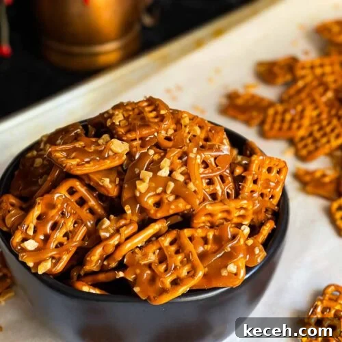 Buttery Toffee Pretzel Snacks: Sweet & Crunchy Recipe 11 Butter toffee pretzels in a dark bowl on the baking sheet.