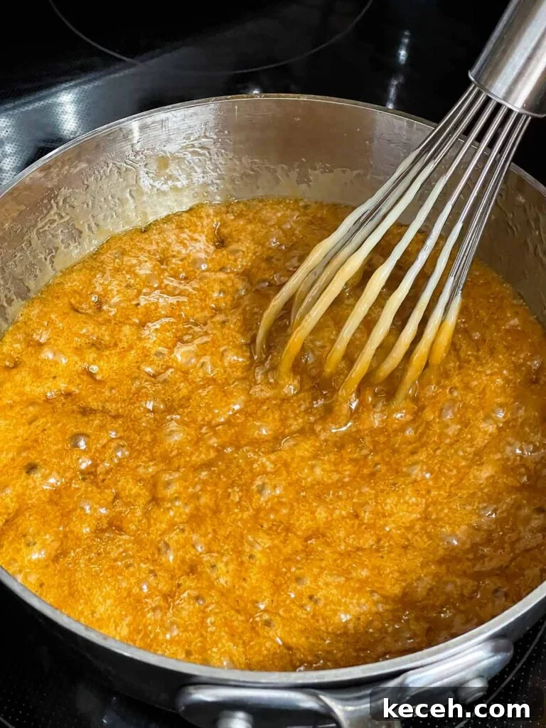 Buttery Toffee Pretzel Snacks: Sweet & Crunchy Recipe 5 Toffee mixture boiling in a metal saucepan.