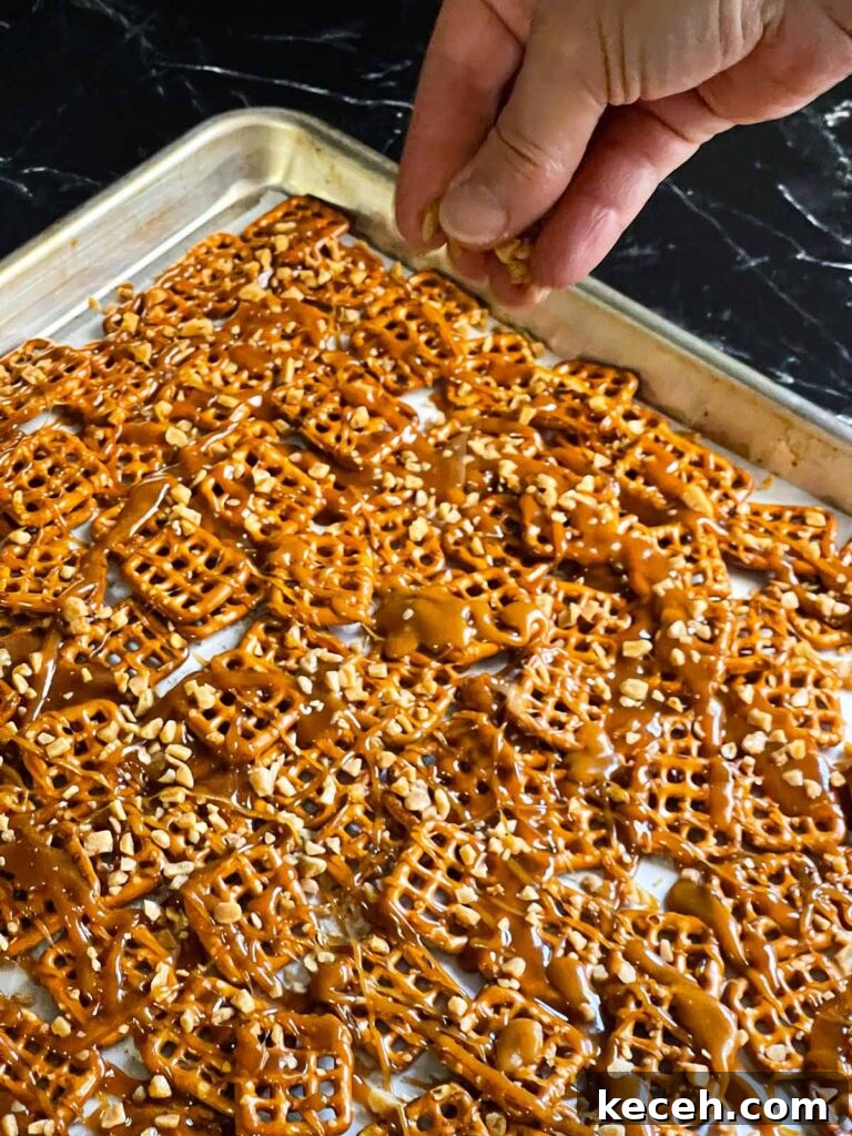 Buttery Toffee Pretzel Snacks: Sweet & Crunchy Recipe 7 Sprinkling toffee bits over the warm drizzled toffee on the pretzels.