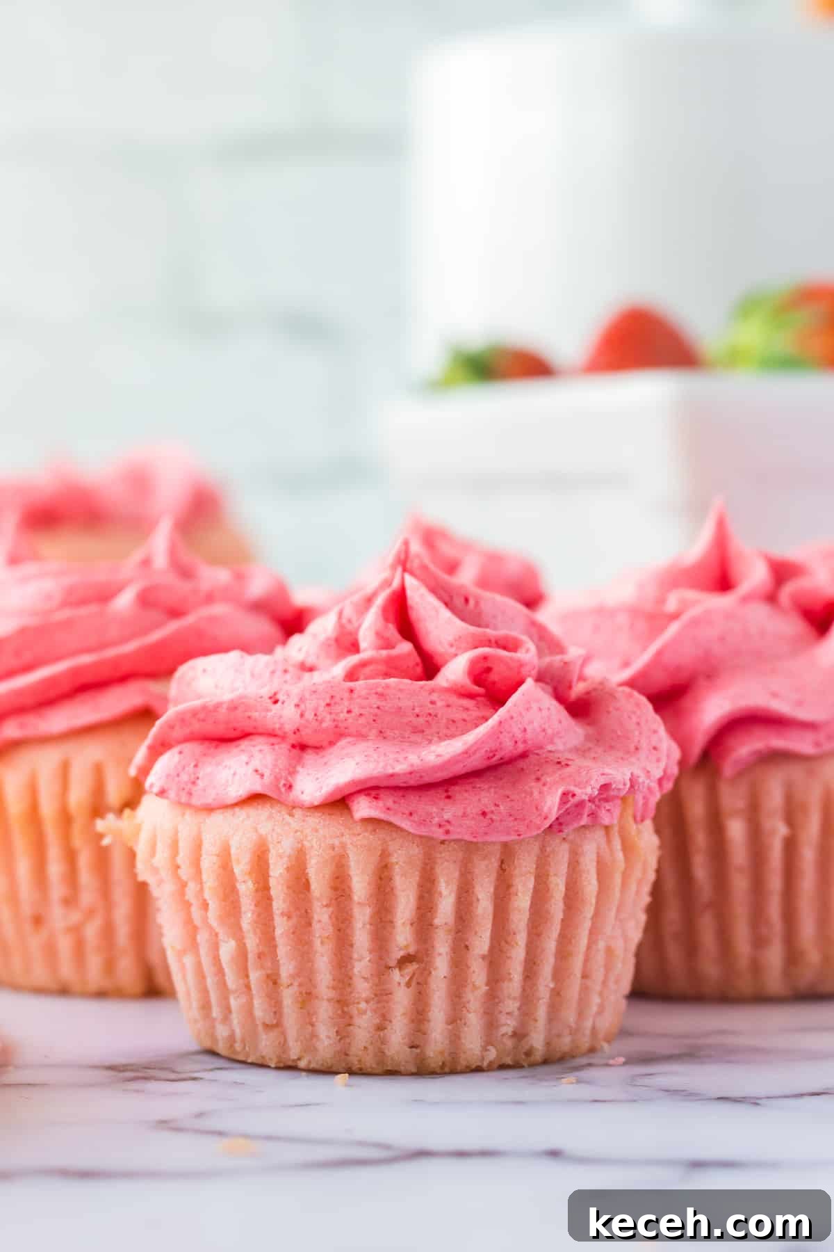 Strawberry-Filled Cupcakes with Fresh Strawberry Filling 9 Pink strawberry cupcakes with frosting.