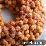 A pile of honey balls on a platter topped with nonpareil sprinkles