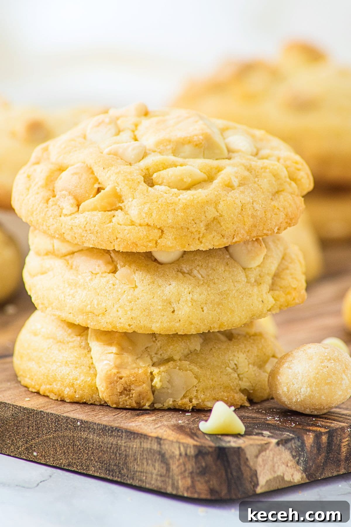 White Chocolate Macadamia Cookies (Gluten-Free, Dairy-Free) A stack of white chocolate macadamia cookies on wooden board.