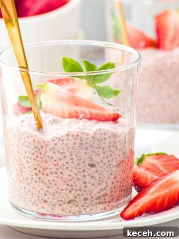A vase of strawberry chia pudding topped with fresh strawberries.