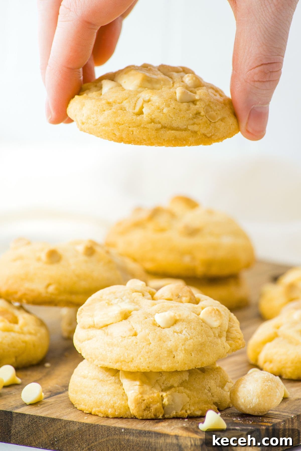 Gluten-Free, Dairy-Free White Chocolate Macadamia Cookies 2 Holding up a macadamia white chocolate cookie from a stack of cookies.