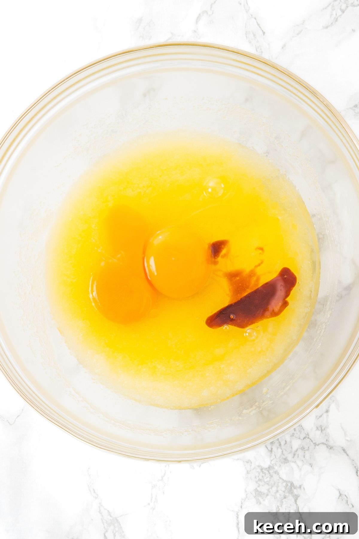 How to Make White Chocolate and Macadamia Cookies Sugar, eggs and butter in glass bowl.