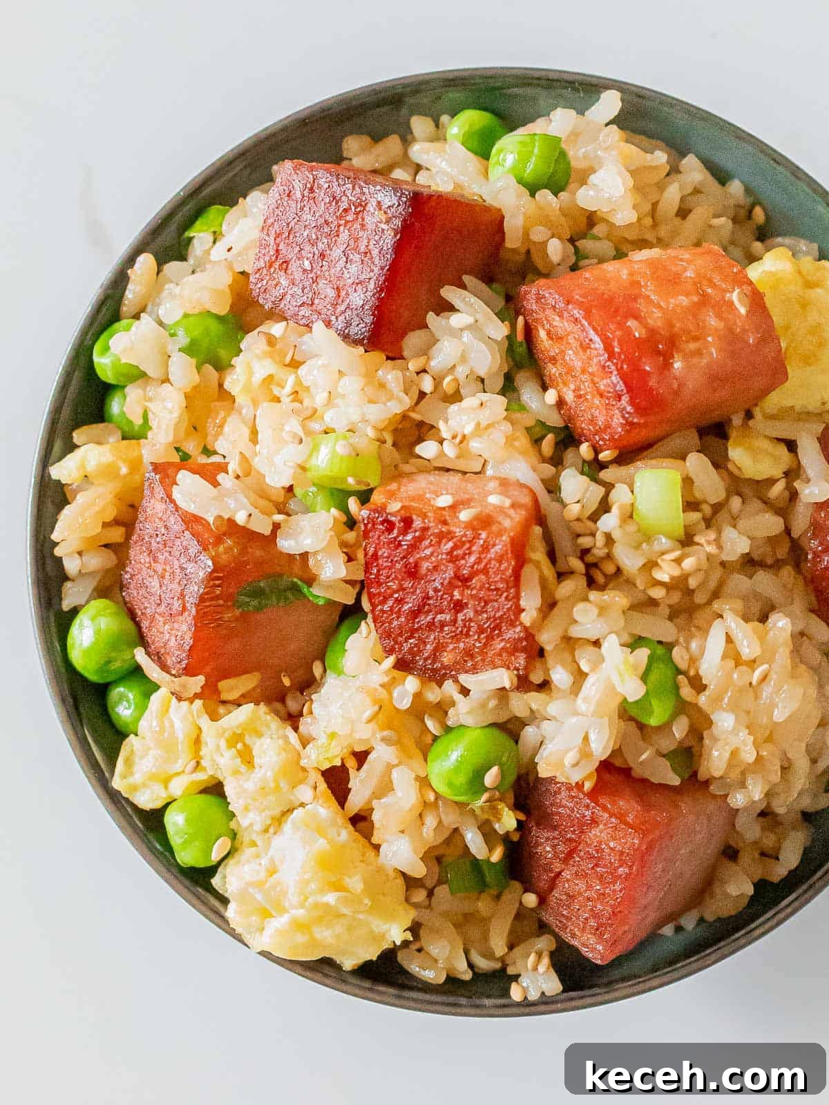 Simple Spam Fried Rice Recipe for Quick Weeknight Meals 2 bowl of spam fried rice with crispy cubes of spam, eggs, green peas, and sesame seeds