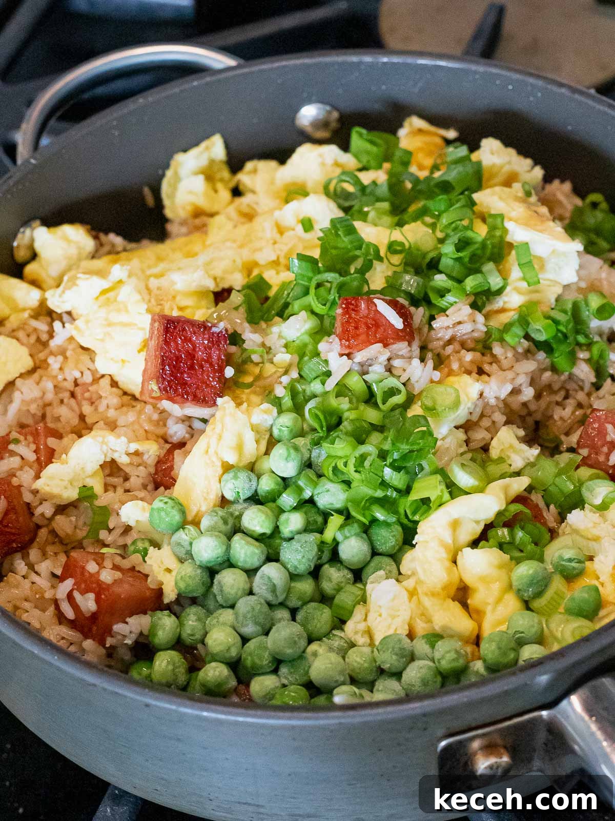 Simple Spam Fried Rice Recipe for Quick Weeknight Meals 12 ingredients for spam fried rice in a nonstick pan including green peas and scallions
