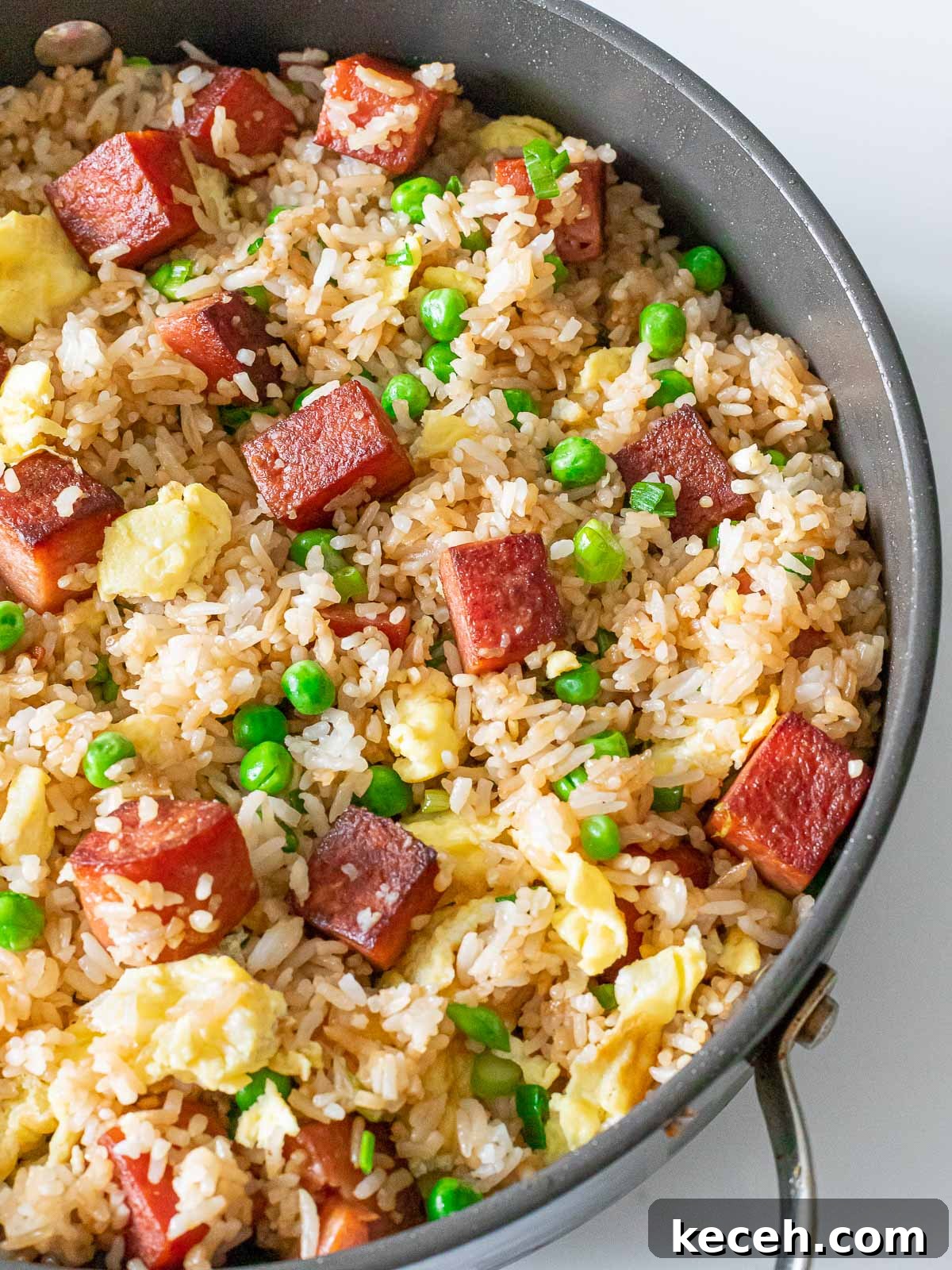 Simple Spam Fried Rice Recipe for Quick Weeknight Meals 14 overhead of spam fried rice with pan fried spam, eggs, and green peas in a pan