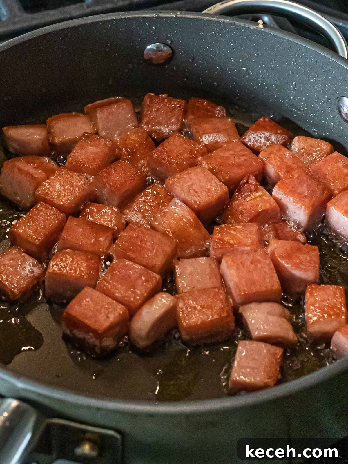 Simple Spam Fried Rice Recipe for Quick Weeknight Meals 9 cubes of spam frying in a nonstick pan