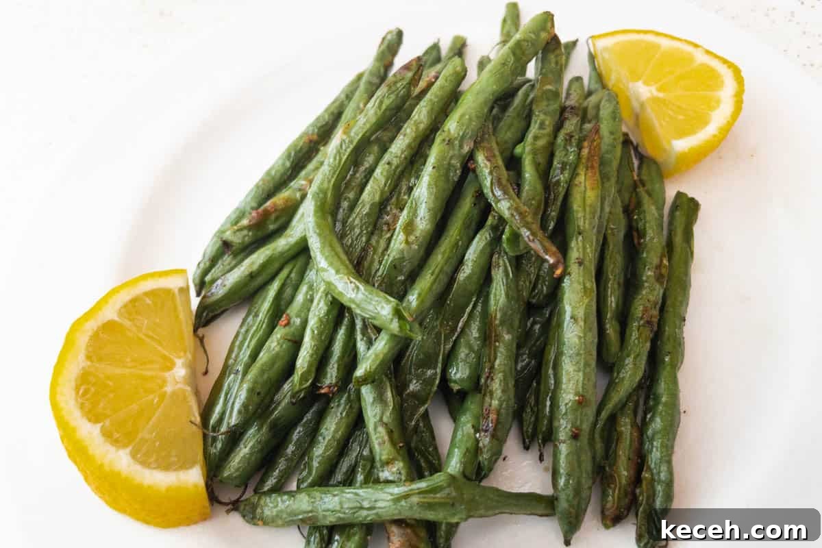 Air Fryer Green Beans in white dish with lemon slices