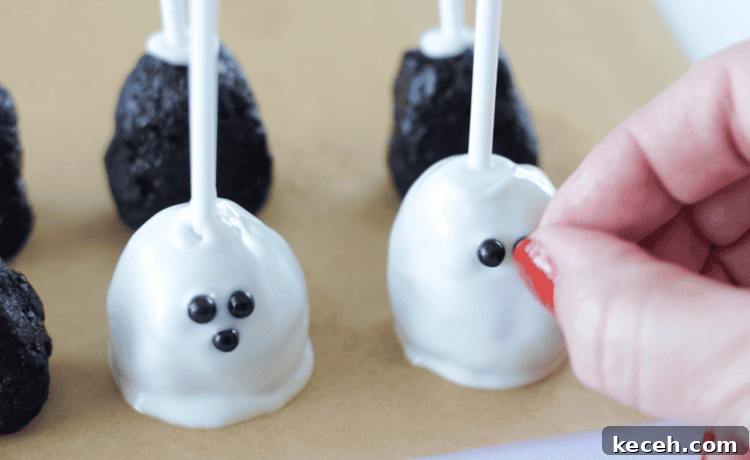 hand pressing black candy sprinkles for ghost face