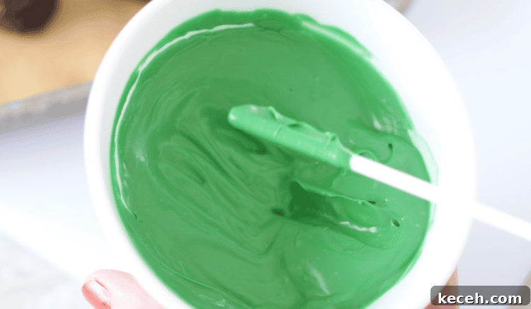 bowl of green melting chocolate with lollipop dipped