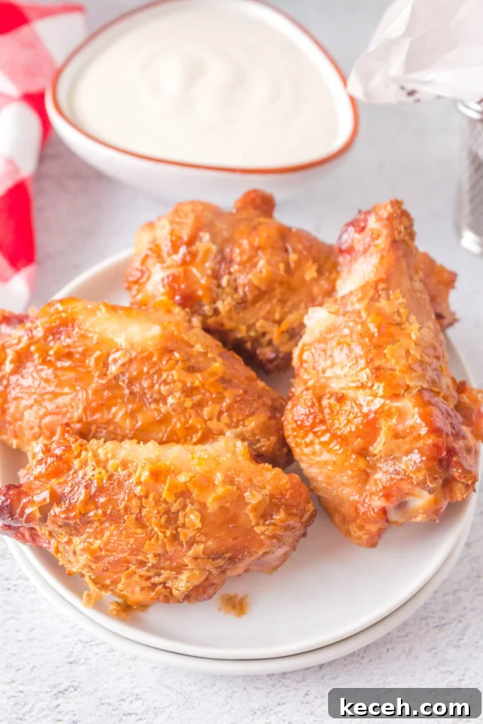 Crispy Grilled Chicken Wings Recipe for Perfectly Charred Skin 2 four grilled crispy chicken wings on plate next to dip