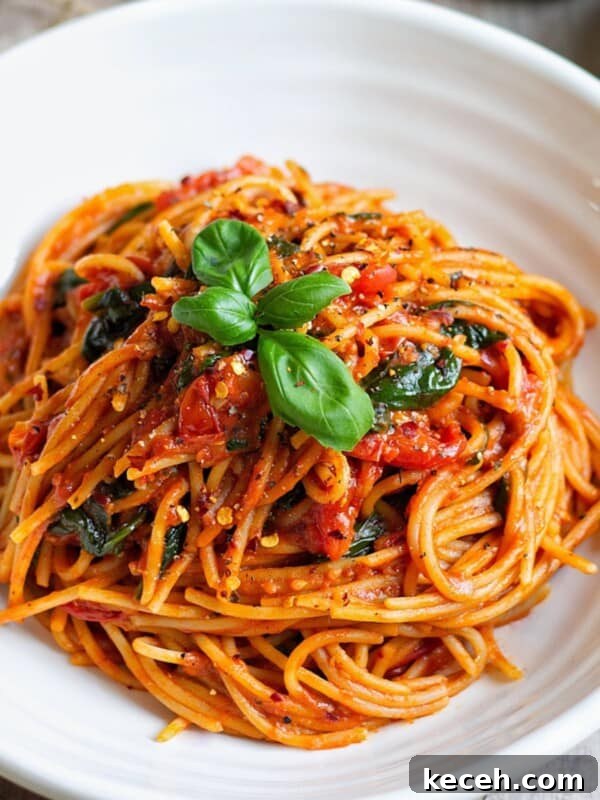 Cherry Tomato Pasta with fresh basil leaves on top.