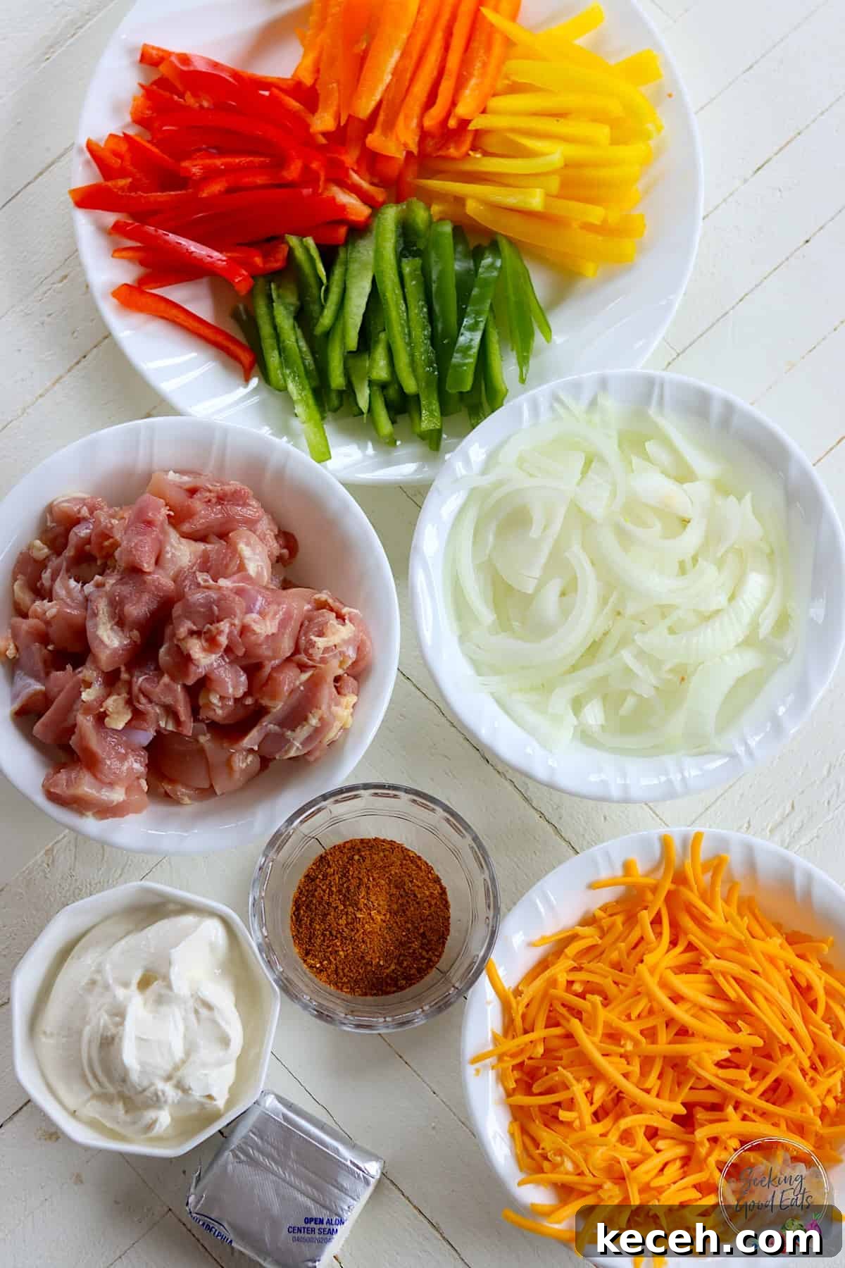 Ingredients needed for making chicken fajita casserole on a white wooden board.