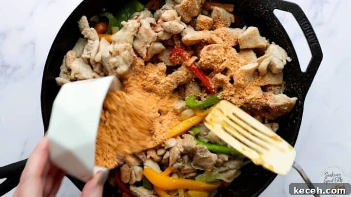 Adding the chicken fajita casserole seasoning to the cooked chicken and peppers.