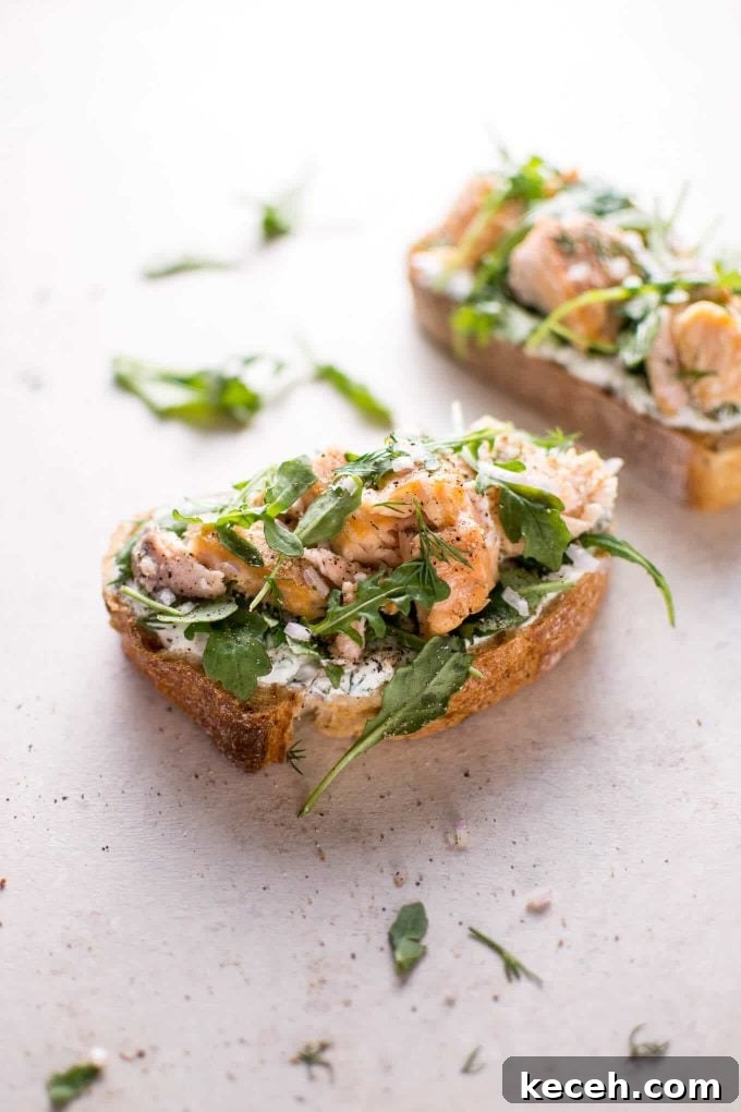 Smoked Salmon Tartine with Lemon-Dill Cream Cheese 3 open-faced sandwich on a counter with lemon, dill, shallots, and arugula