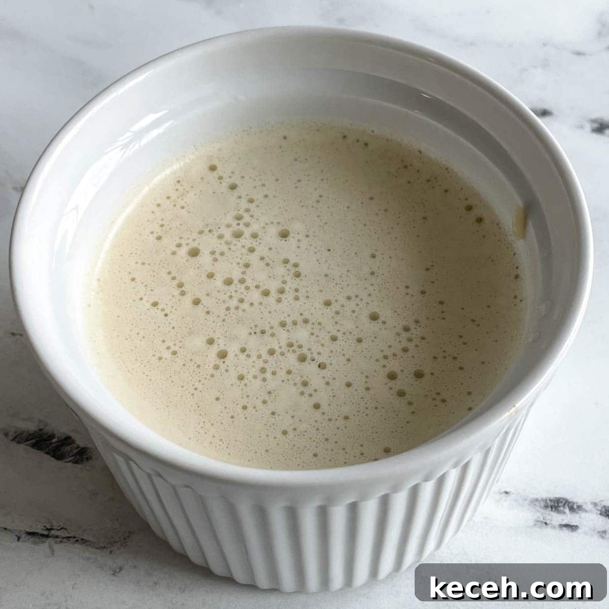 Authentic Greek Chickpea Soup (Revithosoupa) Recipe 11 Eggs, rice, and vegetable broth that have been blended into a liquid are shown in a white ramekin.