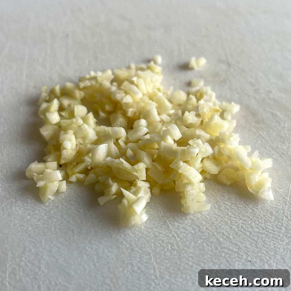 Authentic Greek Chickpea Soup (Revithosoupa) Recipe 6 Minced garlic sits on a white cutting board.