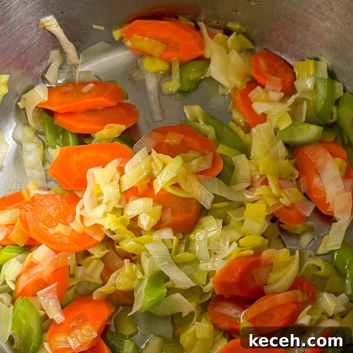 Authentic Greek Chickpea Soup (Revithosoupa) Recipe 7 Sauteed carrot, celery, and leek are shown in a stainless steel pot.