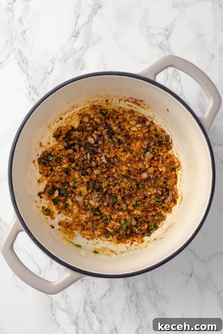 Stir in the seasonings. Overhead view of aromatics and spices sauteed in Dutch oven