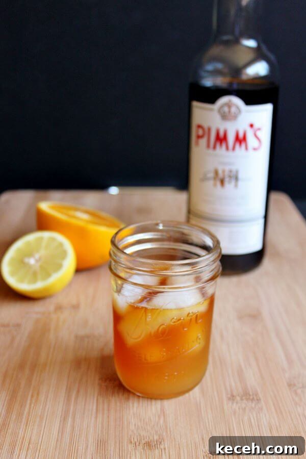 Pimm’s Sundowner Cocktail Recipe: Refreshing Evening Drink 5 Making a Pimm's Sundowner, adding liquid ingredients.