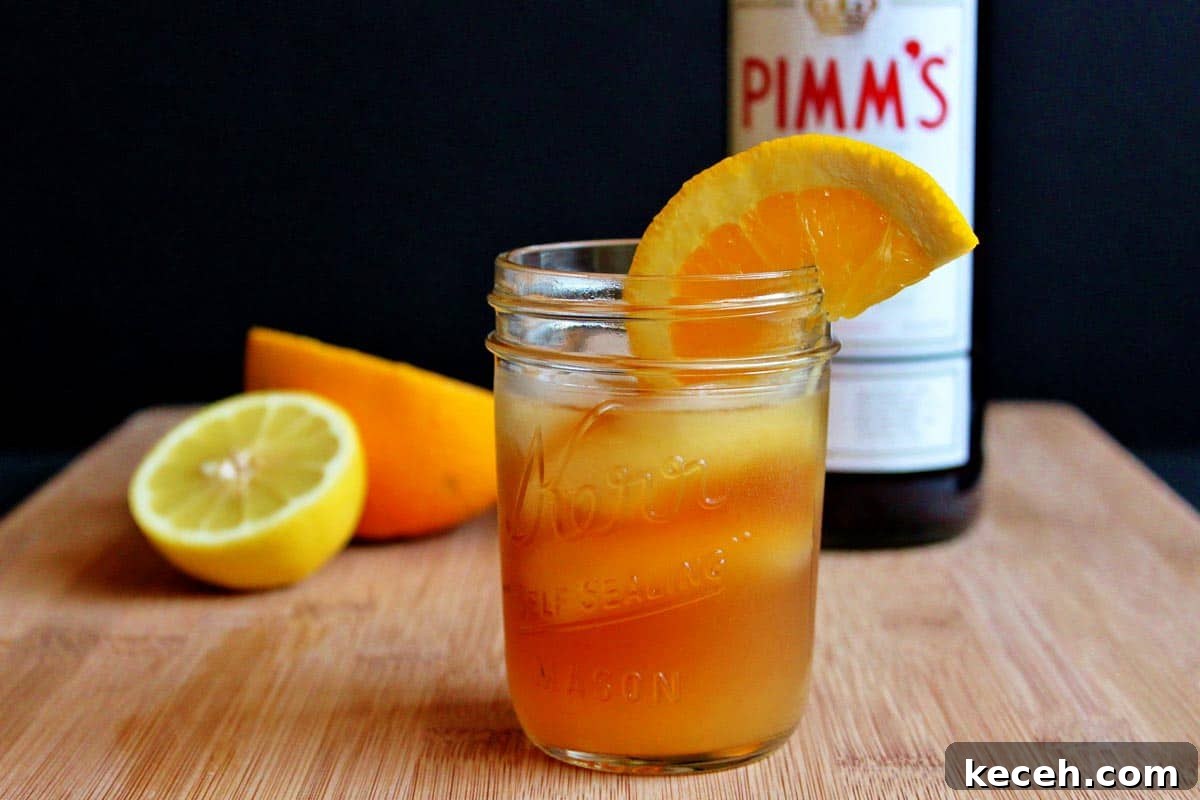 Pimm’s Sundowner Cocktail Recipe: Refreshing Evening Drink 6 A glass of Pimm's sundowner cocktail in front of a bottle of Pimm's.