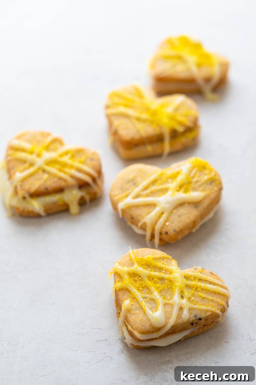 Lemon Poppy Seed Heart-Shaped Sandwich Cookies 12 a row of lemon hearts.