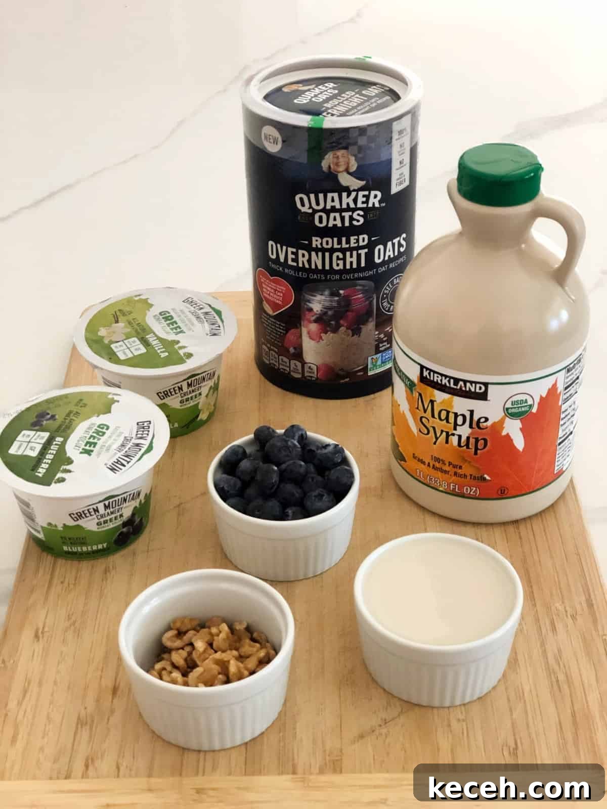 Blueberry and Maple Overnight Oats Recipe for Quick Breakfast 3 Ingredients including maple syrup, walnuts, blueberries, plain Greek yogurt and rolled oats on wood cutting board.