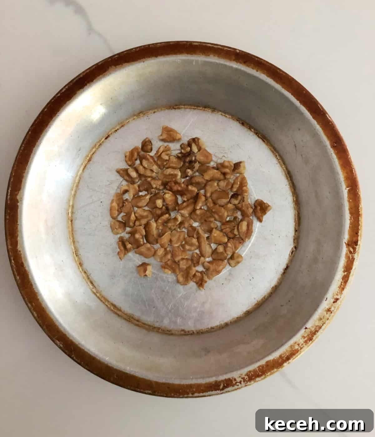 Blueberry and Maple Overnight Oats Recipe for Quick Breakfast 8 Chopped toasted walnuts in pie tin on white marble counter.