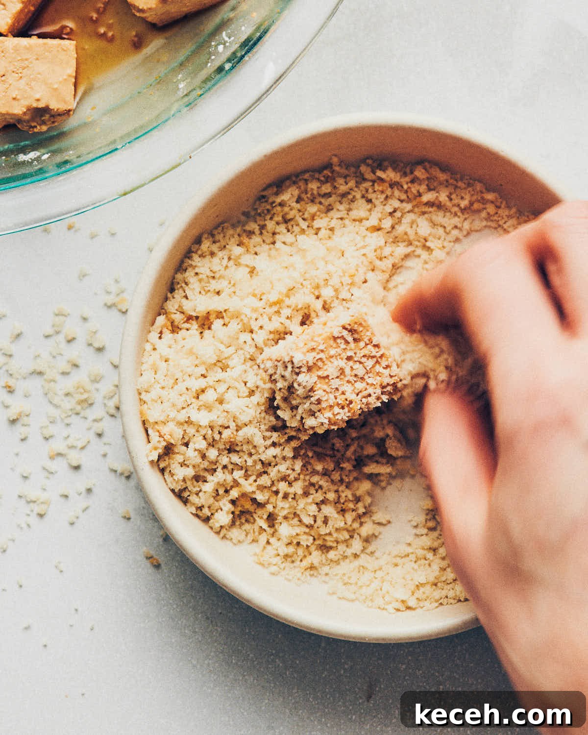 Crispy Air Fryer Breaded Tofu Recipe 13 A hand coating tofu in crispy panko breadcrumbs