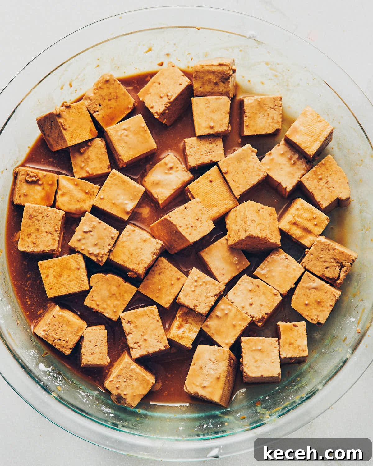 Crispy Air Fryer Breaded Tofu Recipe 8 Cubed tofu sitting in a shallow glass dish of tamari to marinate