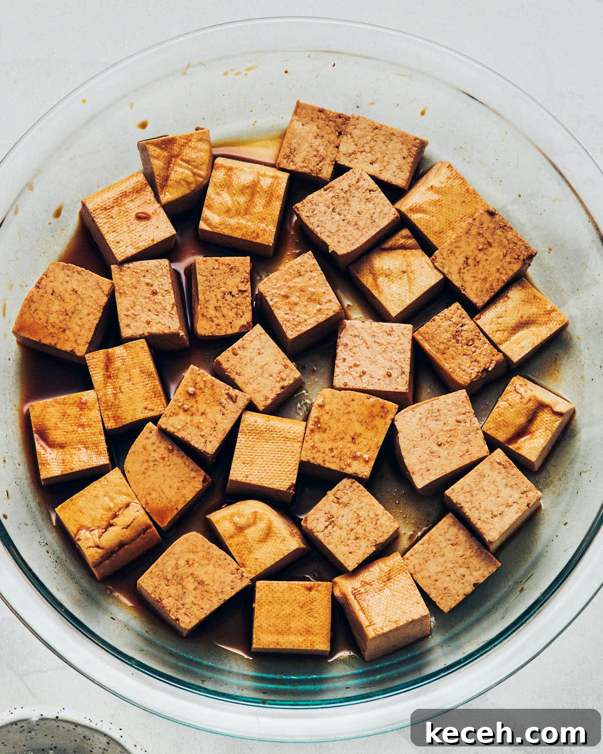 Crispy Air Fryer Breaded Tofu Recipe 9 Cubed tofu that has absorbed tamari after marinating in a shallow clear glass dish