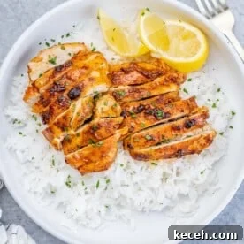 Crispy Air Fryer Boneless Chicken Thighs Recipe 9 top view of a round white bowl with steamed white rice and sliced air-fried boneless chicken thighs