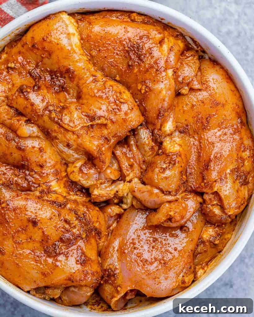 Crispy Air Fryer Boneless Chicken Thighs Recipe 6 Chicken thighs marinating in a white bowl.