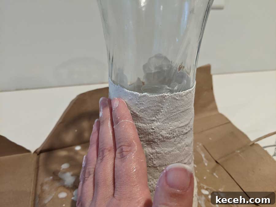 smooth plaster cloth onto vase