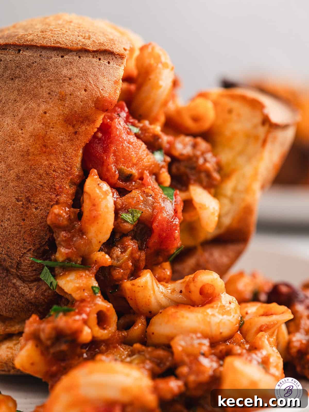 Close up of a chili mac stuffed popover with the chili mac spilling out
