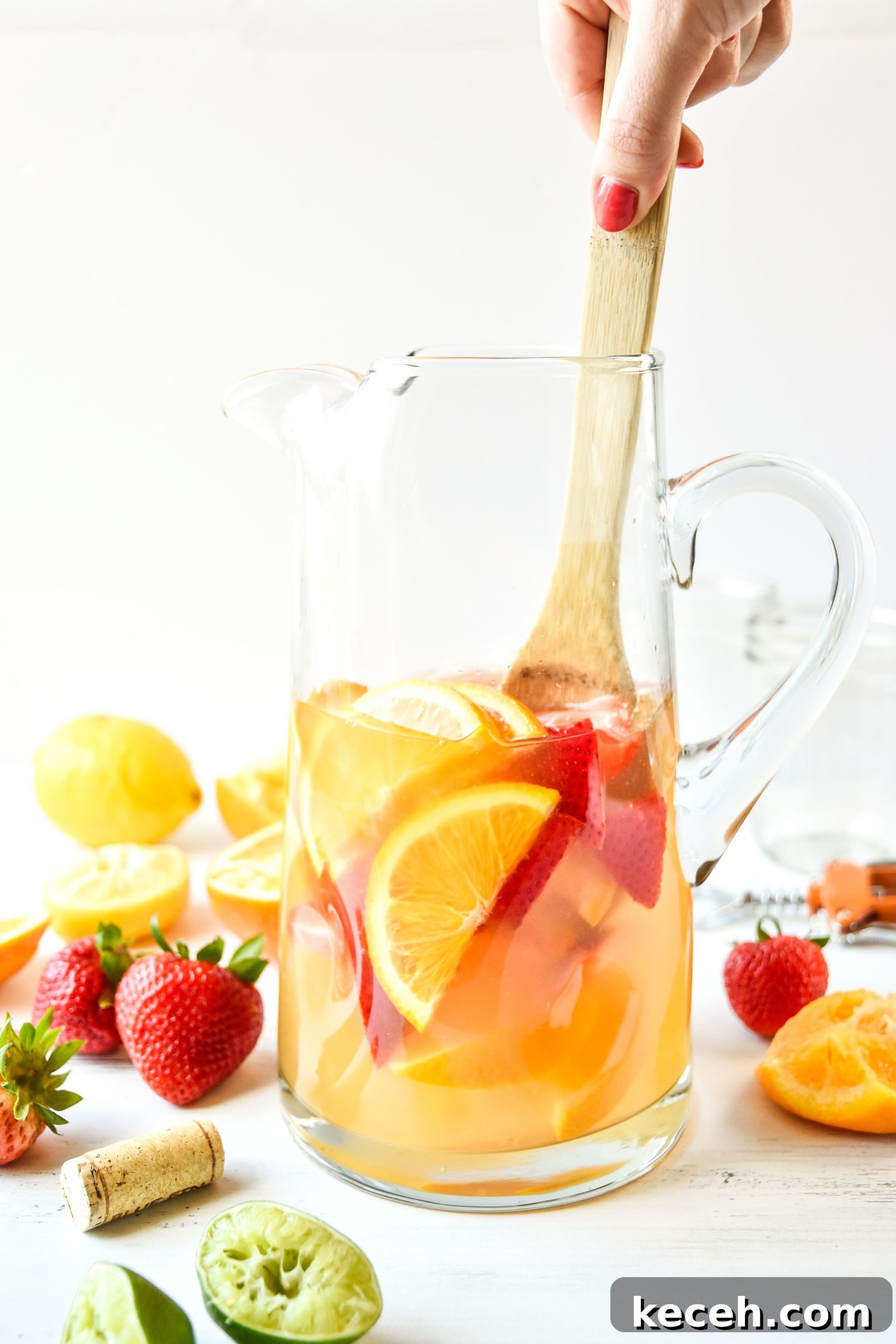Refreshing White Wine Sangria Recipe for Summer Gatherings 2 Pitcher of summer white wine sangria being stirred