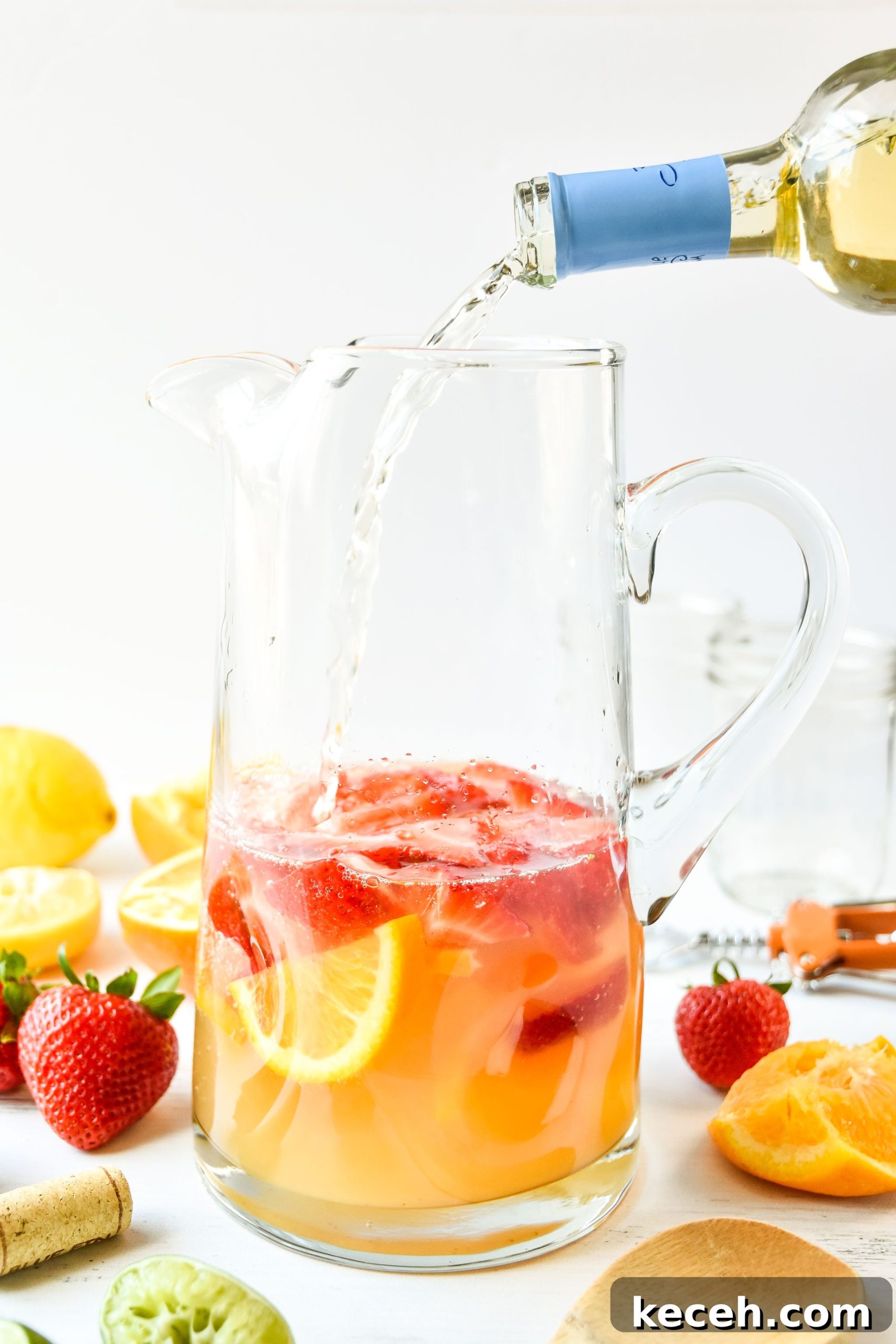 Refreshing White Wine Sangria Recipe for Summer Gatherings 3 Pouring wine into pitcher of summer white wine sangria
